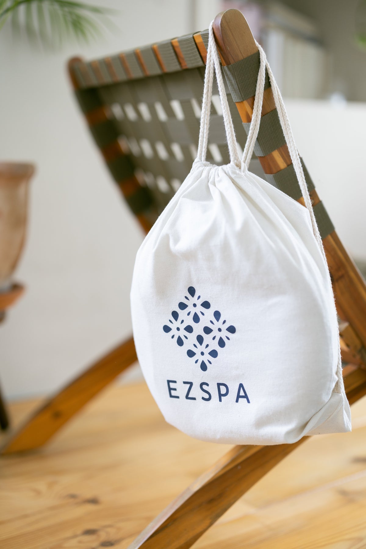 Ezspas bomuldstaske med logoet, hængende på en stol