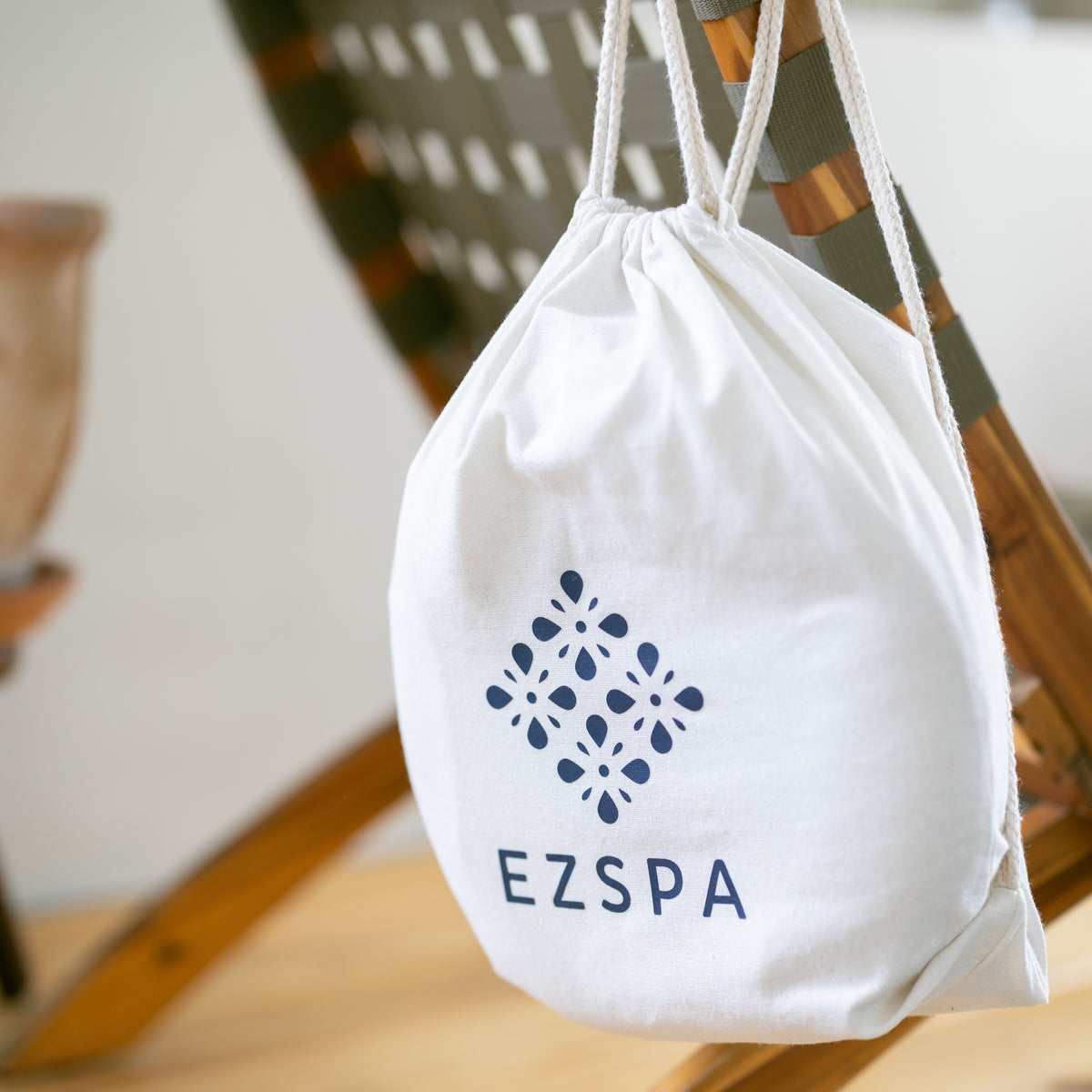 Ezspas bomuldstaske med logoet, hængende på en stol