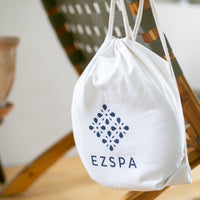 Ezspas bomuldstaske med logoet, hængende på en stol